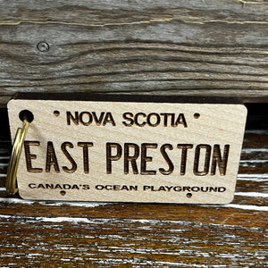 Wooden rectangle liscence plate ornament reads "East Preston" and "Canada's Ocean Playground in smaller font. 