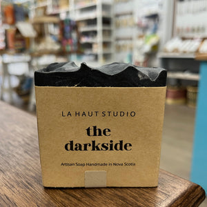 Dark black soap bar with kraft paper label