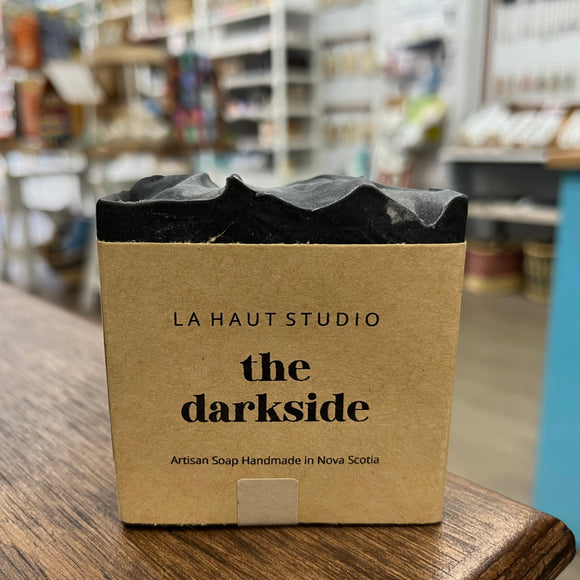 Dark black soap bar with kraft paper label